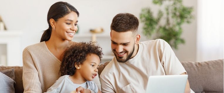 diverse-family-using-laptop-on-sofa-together-picture-id1282618112